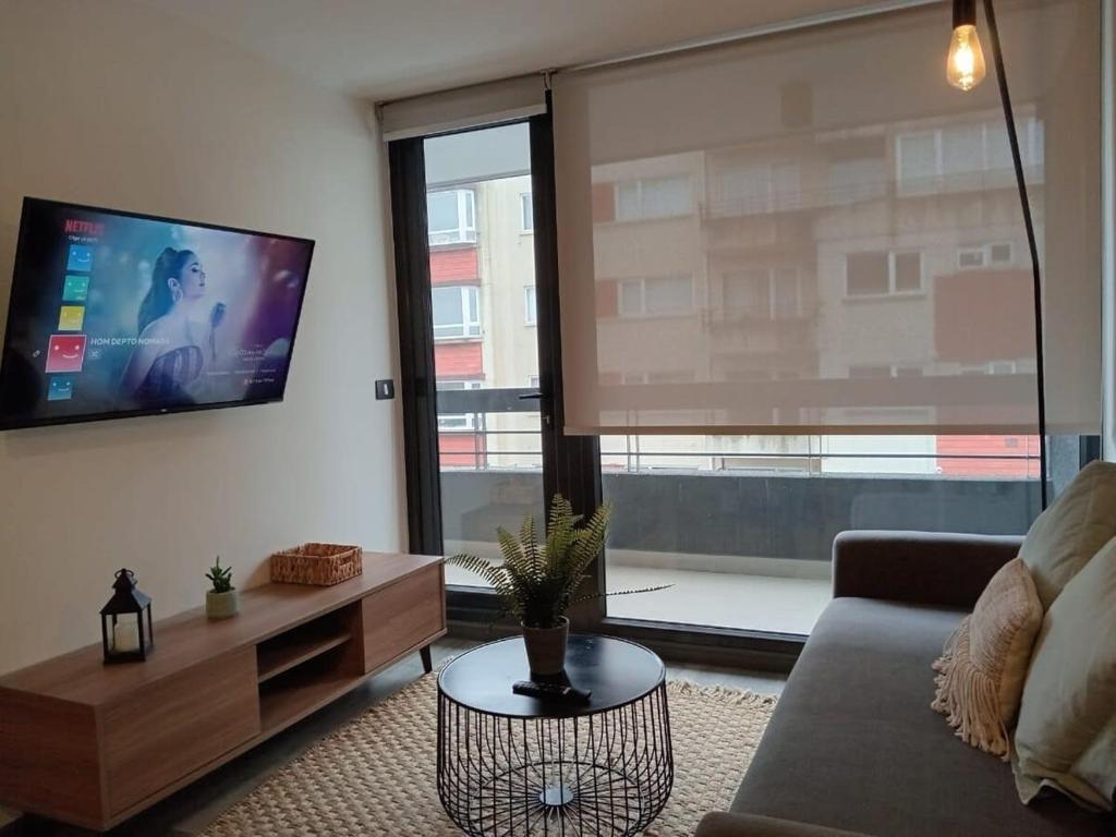a living room with a couch and a flat screen tv at Depto 4PAX en la Mejor Ubicación de Puerto Varas in Puerto Varas