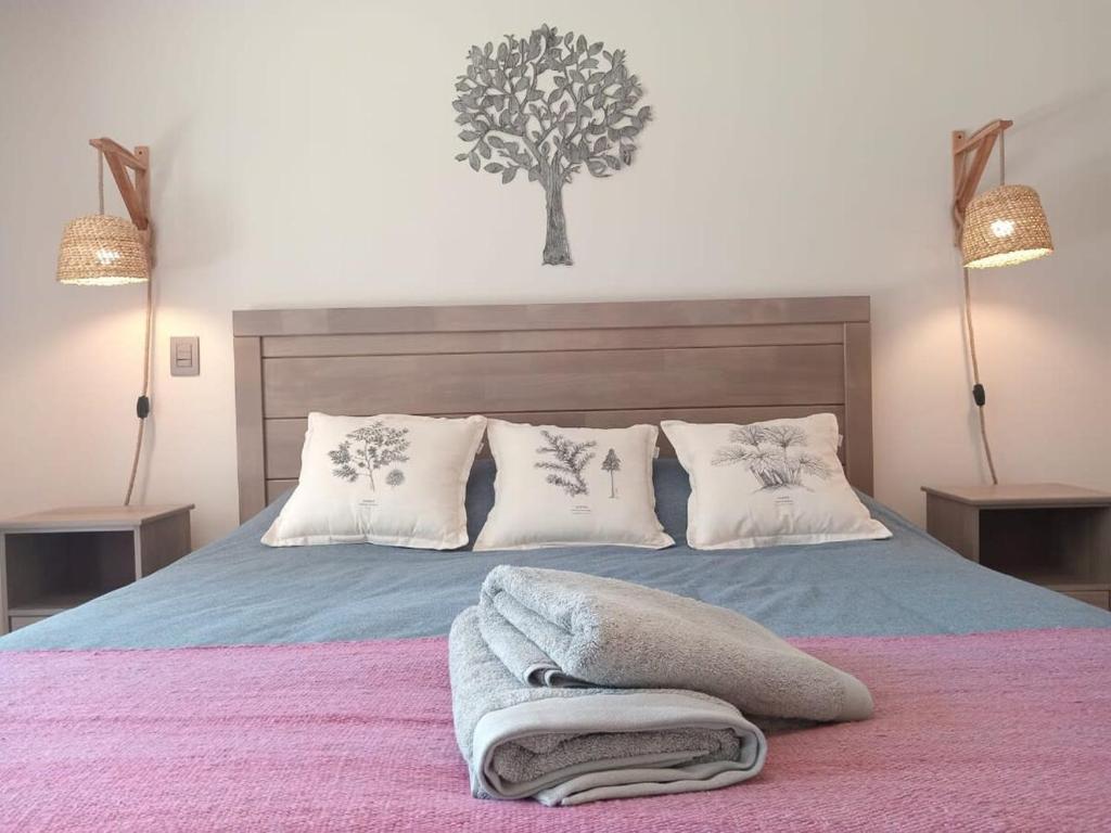 a bedroom with a bed with a tree on the wall at Amplio Depto de 2 dormitorios Frente al Lago y Parking Servicio HOM in Puerto Varas