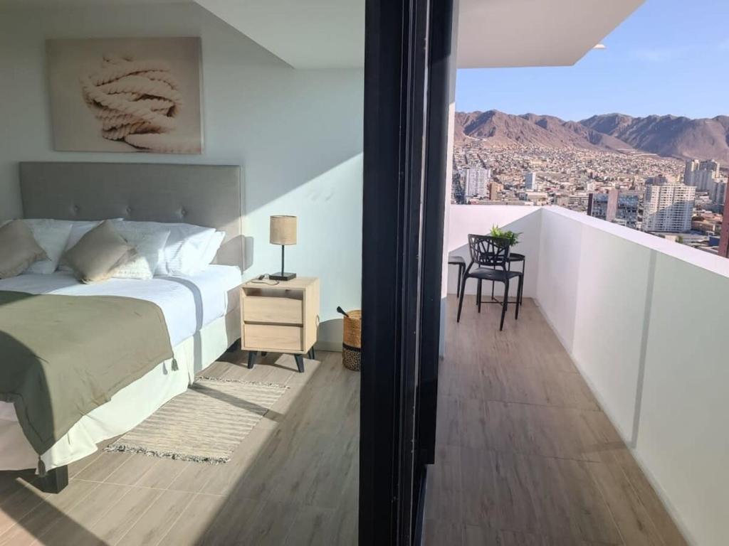 een slaapkamer met een bed en uitzicht op de stad bij Depto 1D1B Frente al Mall con Terraza Vista al Mar Servicio HOM 2312 in Antofagasta