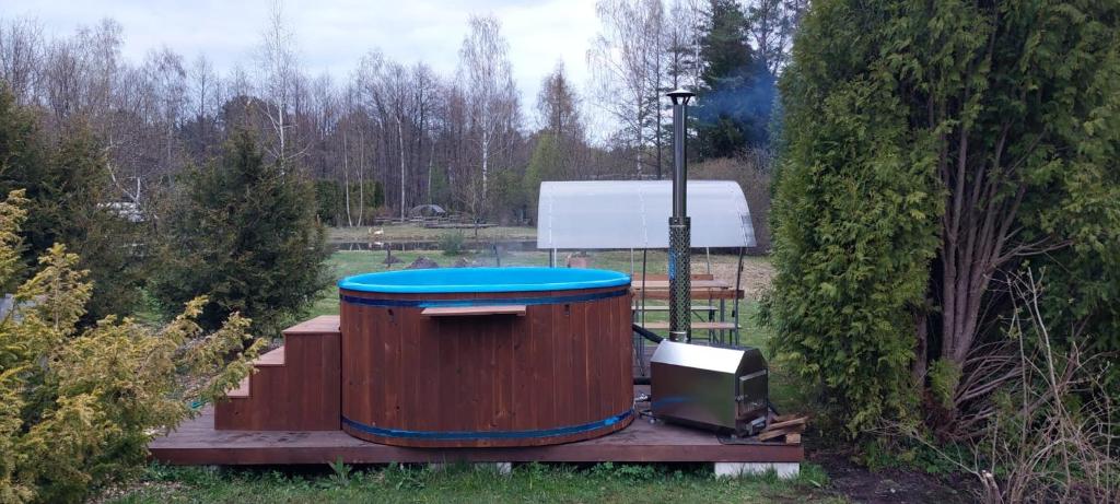 a wooden barrel with a blue lid sitting on a wooden deck at Hot Tub with Wigwam Fluffy Horns - Kubls ar vigvamu Pūkainie Ragi in Plieņciems