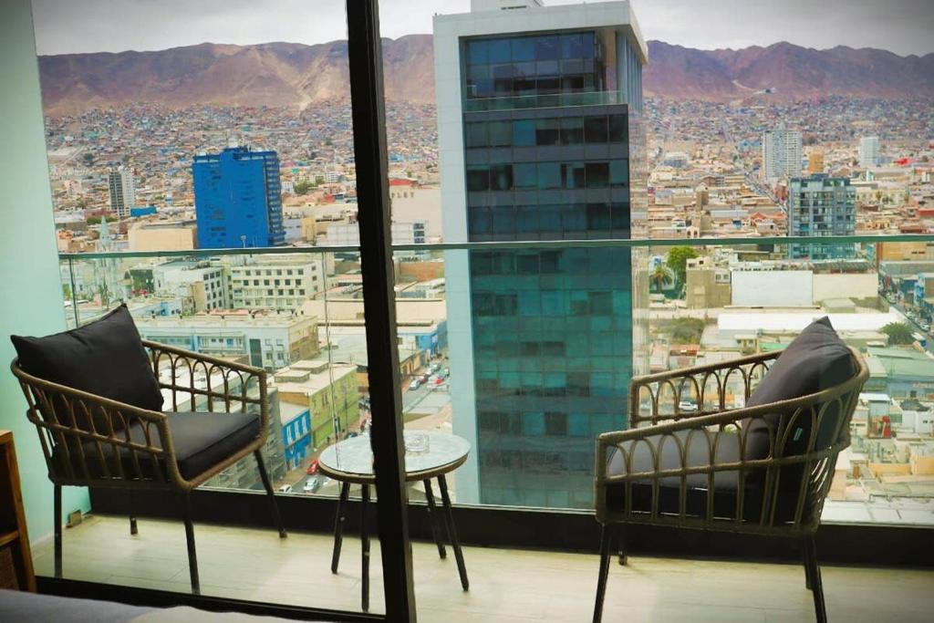 Habitación con 2 sillas, mesa y ventana en Acogedor depto Home estudio ServicioHOM 0516, en Antofagasta
