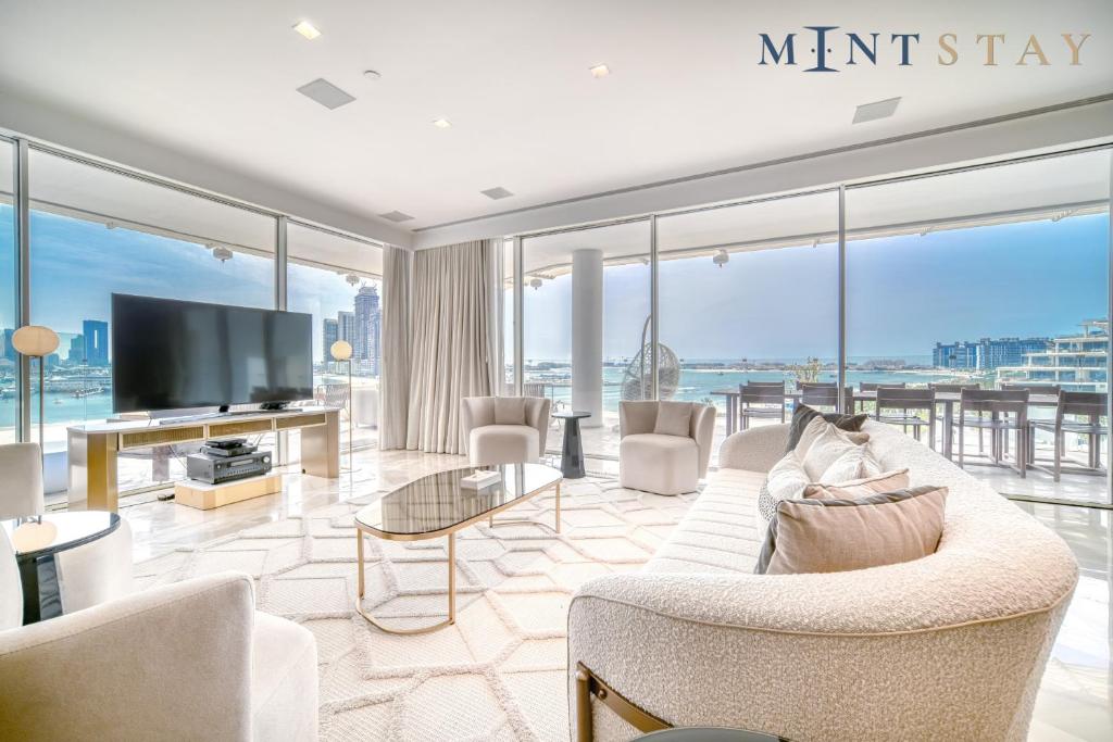 a living room with a couch and a tv at FIVE Palm Jumeirah Residences - Mint Stay in Dubai