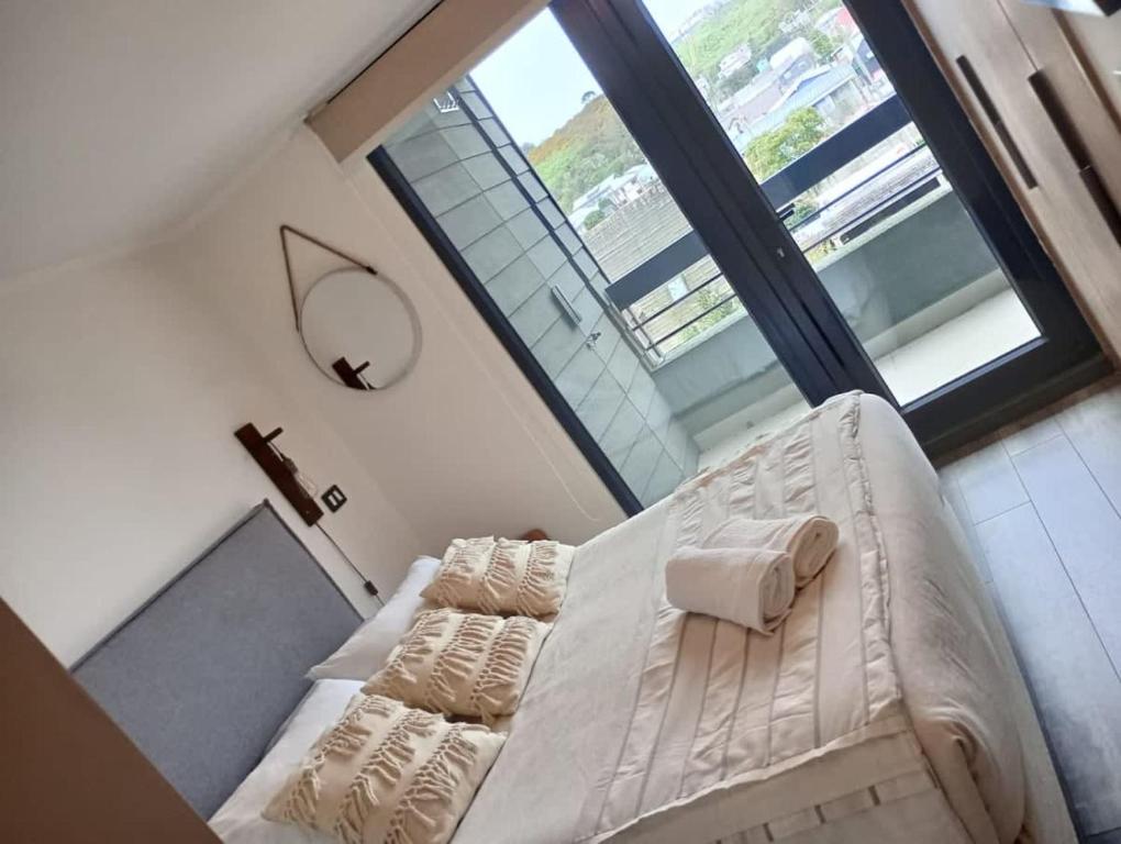 uma cama branca num quarto com uma grande janela em PRECIOSO Depto 1D1B en Pto Varas con parking Servicio HOM em Puerto Varas