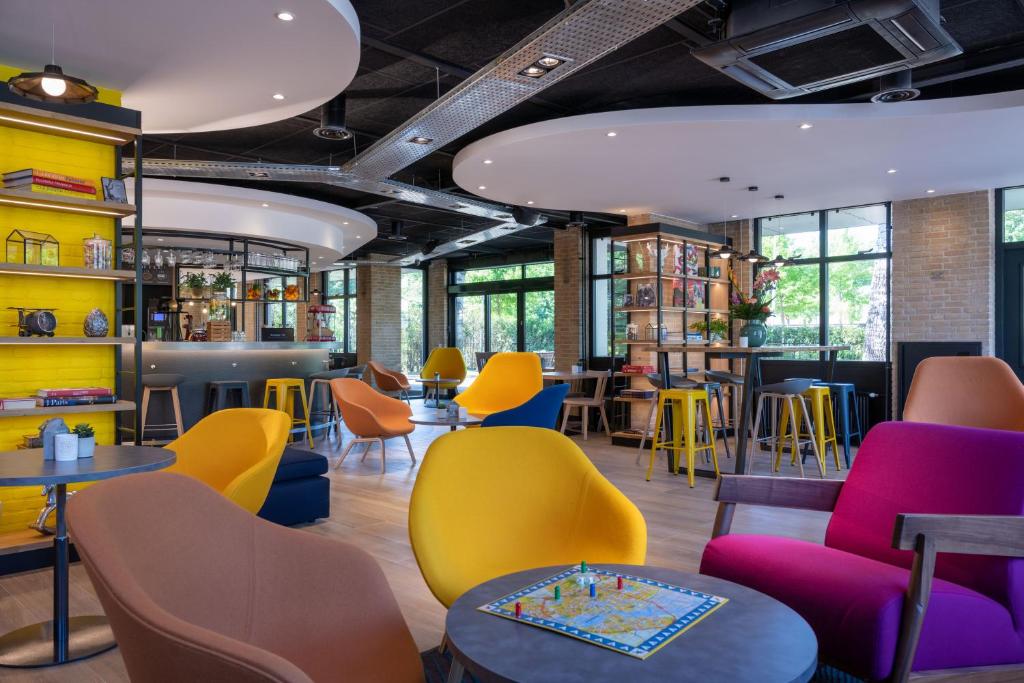uma sala de espera com cadeiras e mesas coloridas em Campanile Hotel & Restaurant Amsterdam Zuid-Oost em Amsterdã