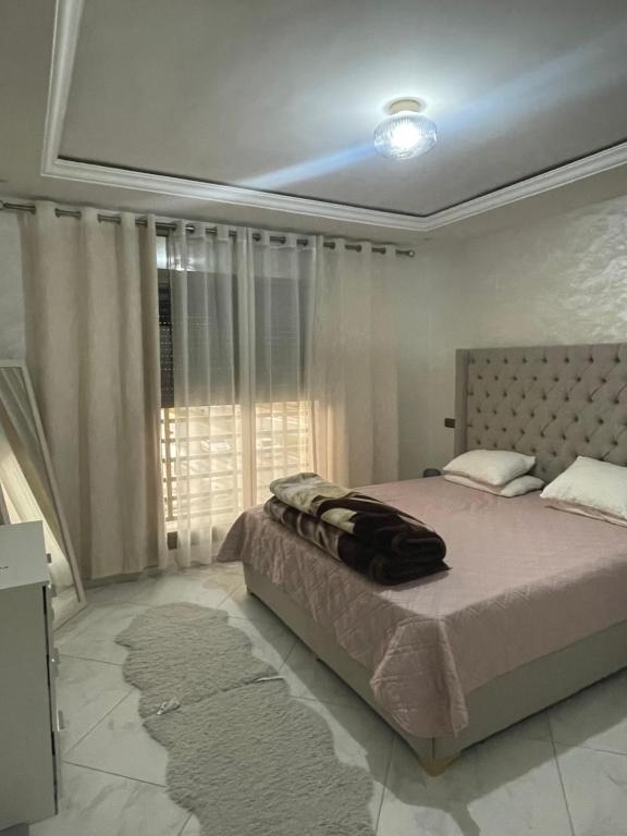 Appartement luxueuse في الناظور: غرفة نوم بسرير كبير مع نافذة كبيرة