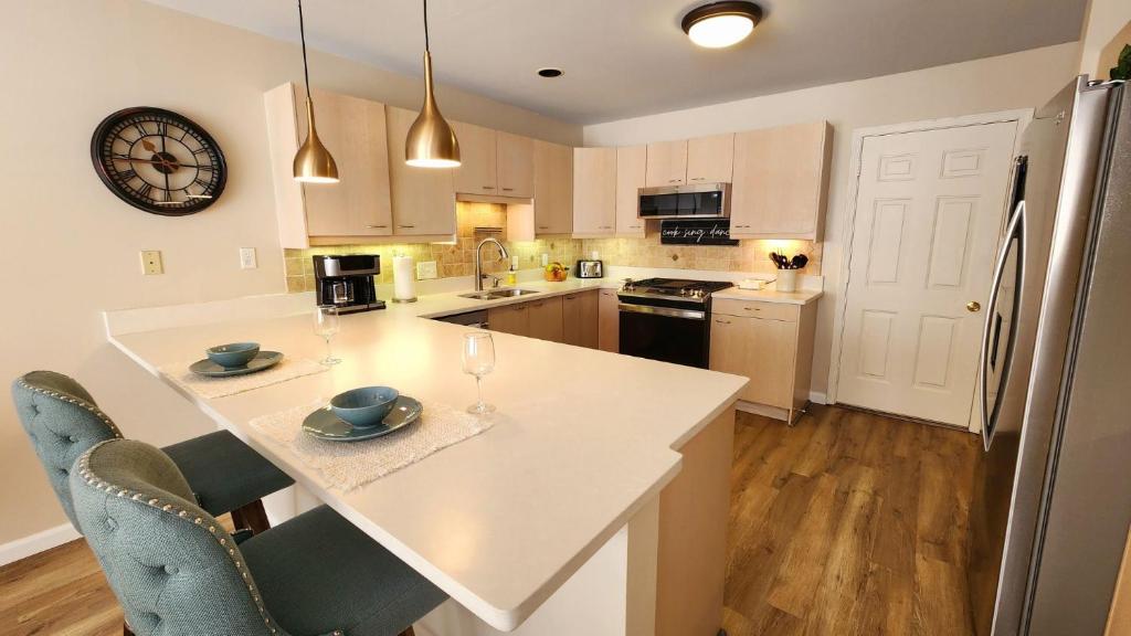 una cucina con un grande piano di lavoro bianco con sedie di Birchwood Dream a Harbor Springs