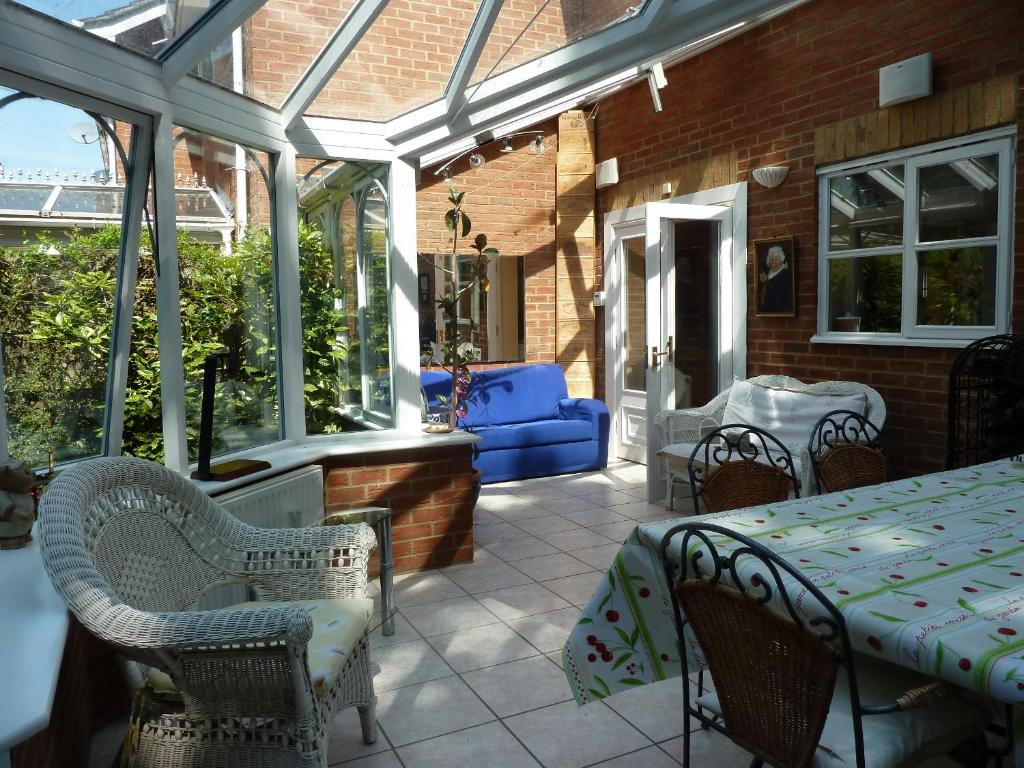 a conservatory with a table and chairs on a patio at spacious in Croxley Green