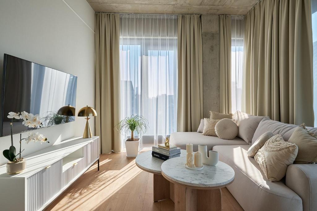 uma sala de estar com um sofá branco e uma mesa em River Premium Apartments em Breslávia