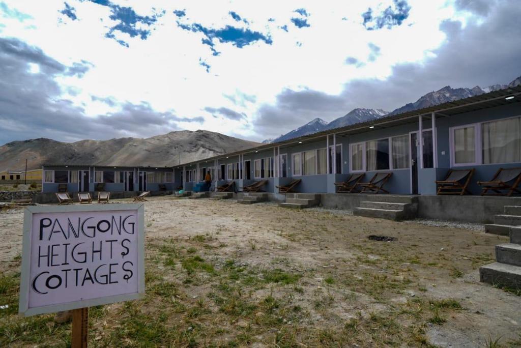 a sign in front of a row of houses at The Pangong Heights Cottages in Leh