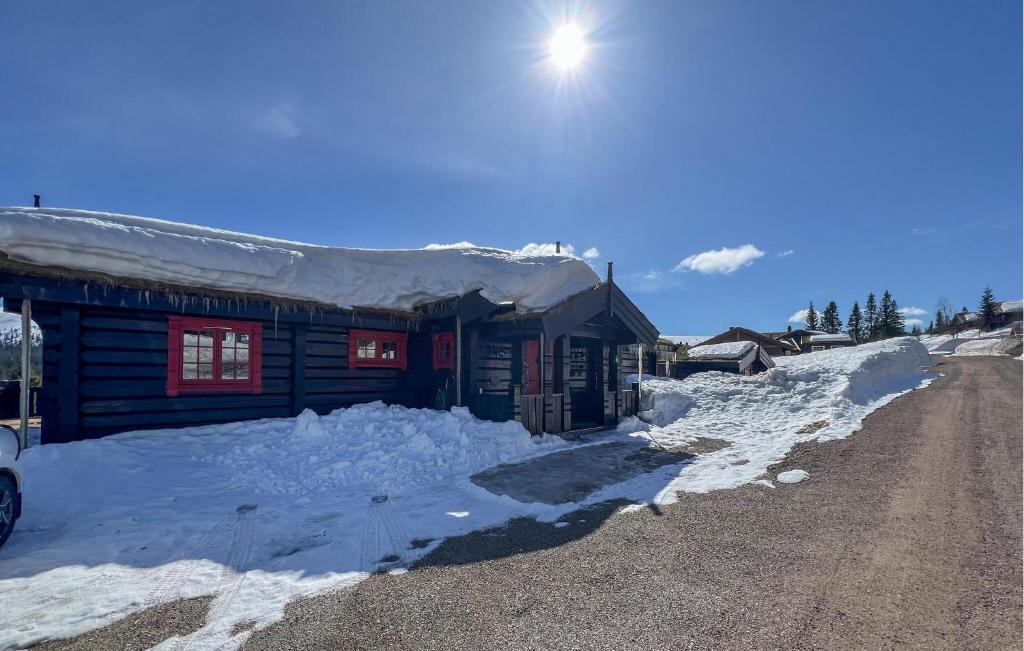 a small cabin with snow on the side of a road at Cozy Home In Trysil With Wifi in Trysil