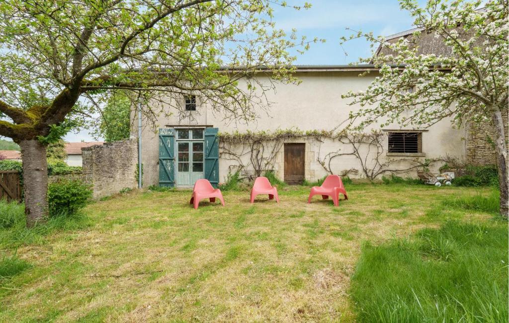 zwei rote Stühle in einem Hof vor einem Haus in der Unterkunft Beautiful Home In Dommartin-le-saint-pr With Wi-fi in Dommartin-le-Saint-Père