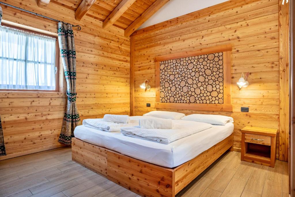 a bedroom with a bed in a wooden room at Chalet Camping Faè 8 - Trilocale in Madonna di Campiglio