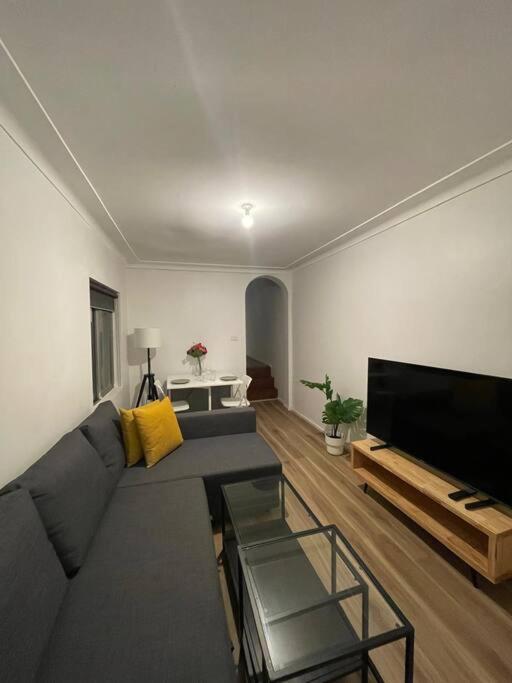 a living room with a couch and a flat screen tv at Close to city 2 Bedroom House Surry Hills in Sydney
