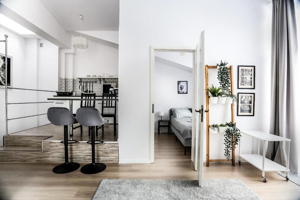 a living room with white walls and a room with a mirror at Fully-furnished Apartment with Air Conditioning for families, Cracow Old Town in Kraków