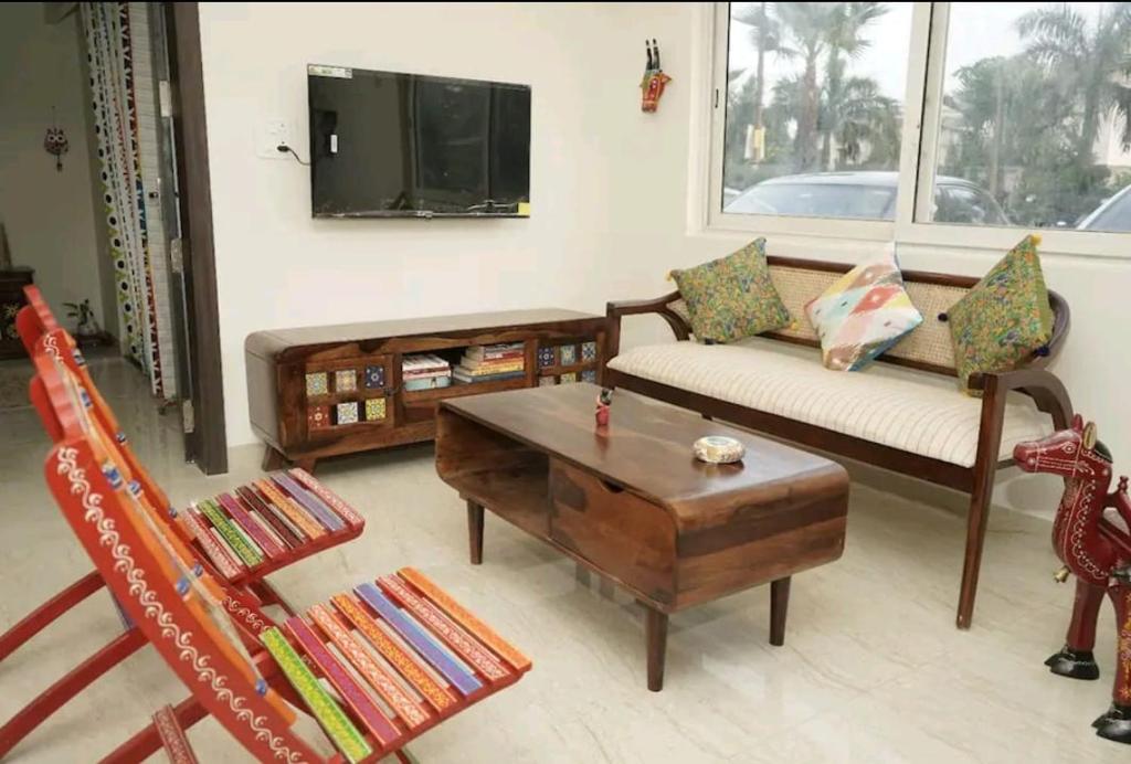 a living room with a couch and a coffee table at Vrunda 2BHK spacious and cozy Homestay in Vrindāvan