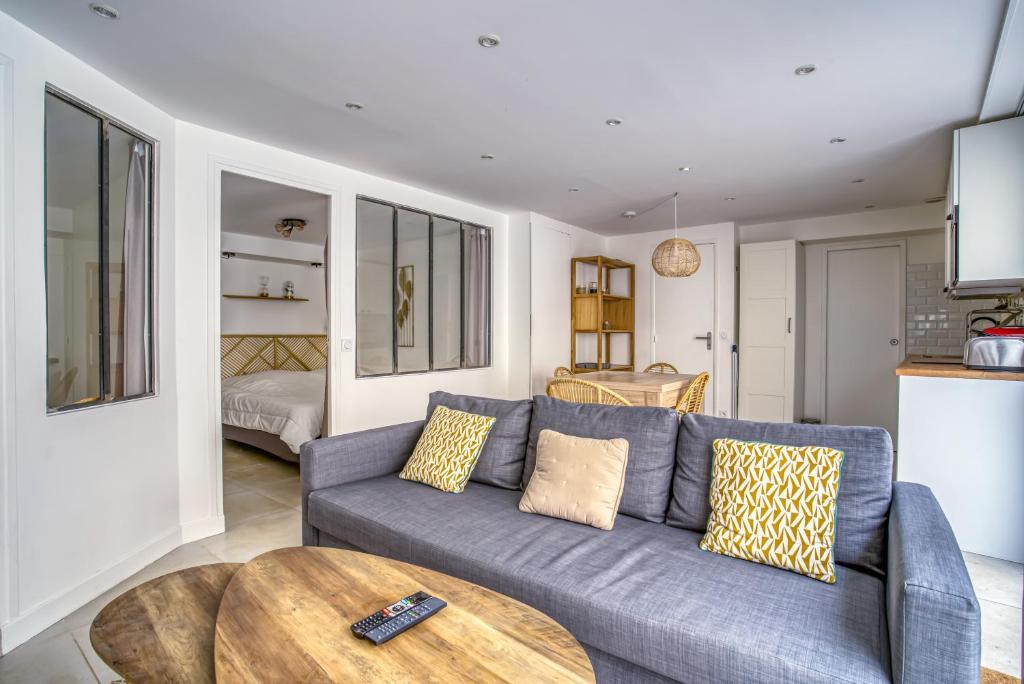 un salon avec un canapé bleu et une table dans l'établissement Nenuphar 3 pièces en RDC Paris 15ème / Felix Faure, à Paris