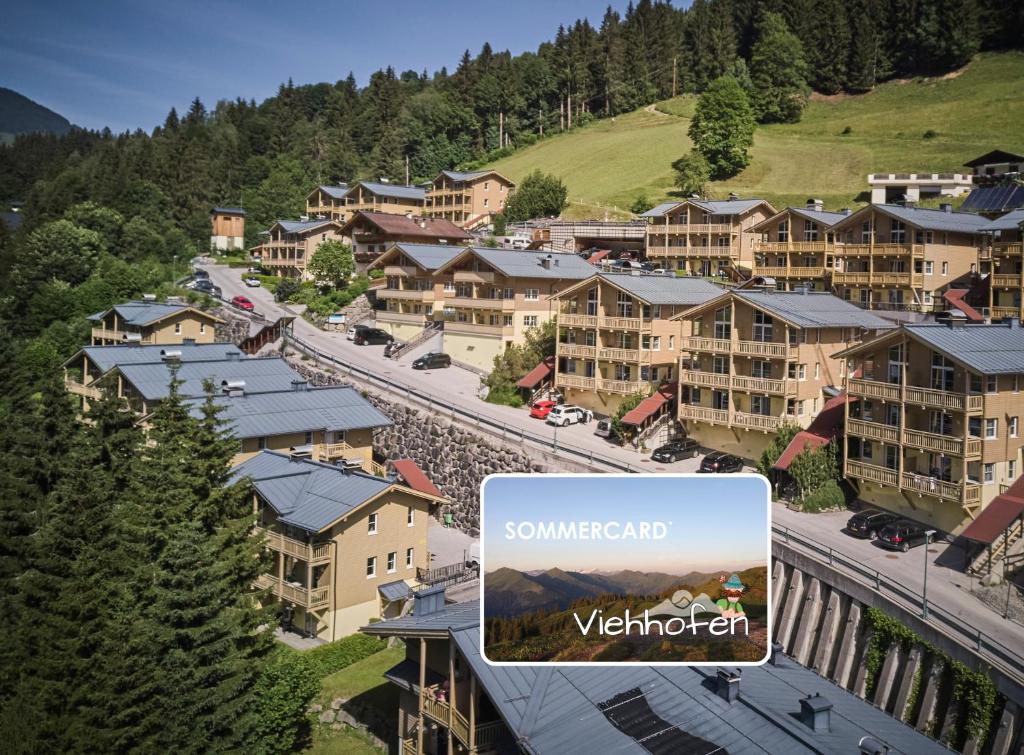 ariaal uitzicht op een resortstad met een bord waarop staat "zomersomed welkom" bij AlpenParks Apartment & Ferienresort Rehrenberg Viehhofen in Viehhofen