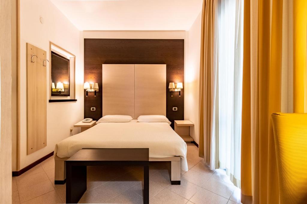sypialnia z białym łóżkiem w pokoju w obiekcie Albergo La Marina B&B w mieście Deiva Marina