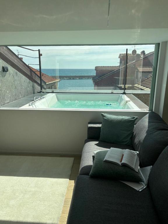 a living room with a couch and a swimming pool at Doria House in Imperia