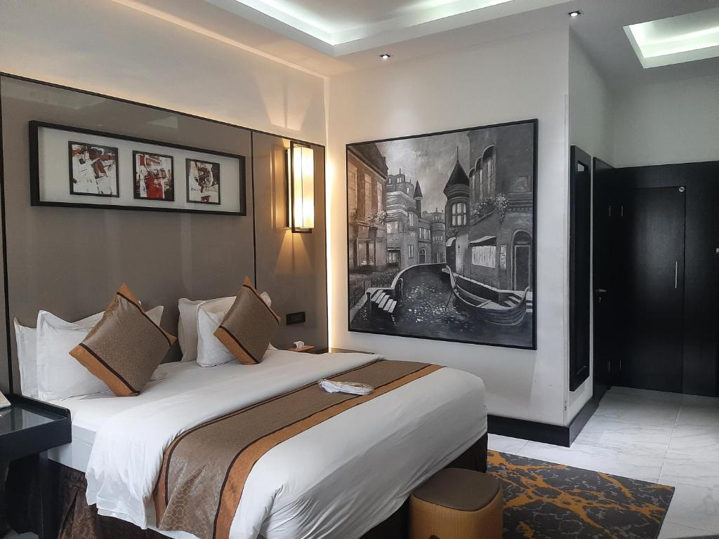 une chambre d'hôtel avec un lit et un tableau sur le mur dans l'établissement GreenPoint Hotel, à Lagos