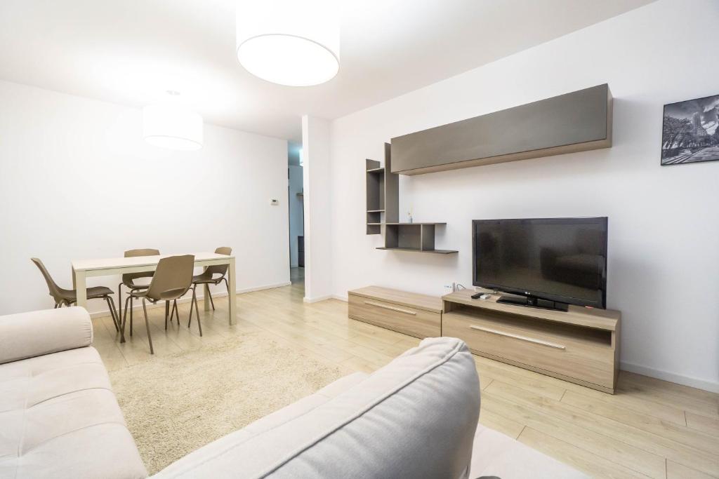 a living room with a couch and a tv and a table at Jasmine Luxury Aviatiei in Herăstrău