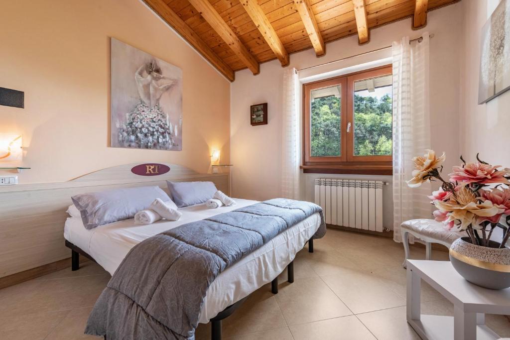 Schlafzimmer mit einem Bett, einem Tisch und einem Fenster in der Unterkunft Residence Tatiana B1 in Tremosine sul Garda