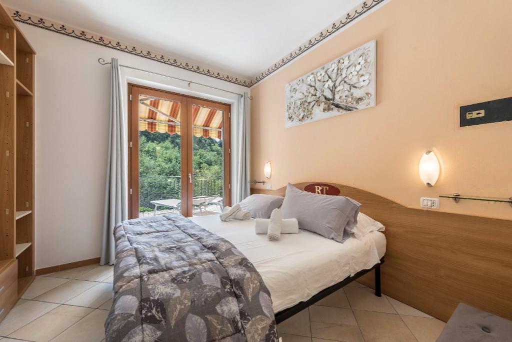um quarto com uma cama e uma grande janela em Residence Tatiana A3 em Tremosine Sul Garda