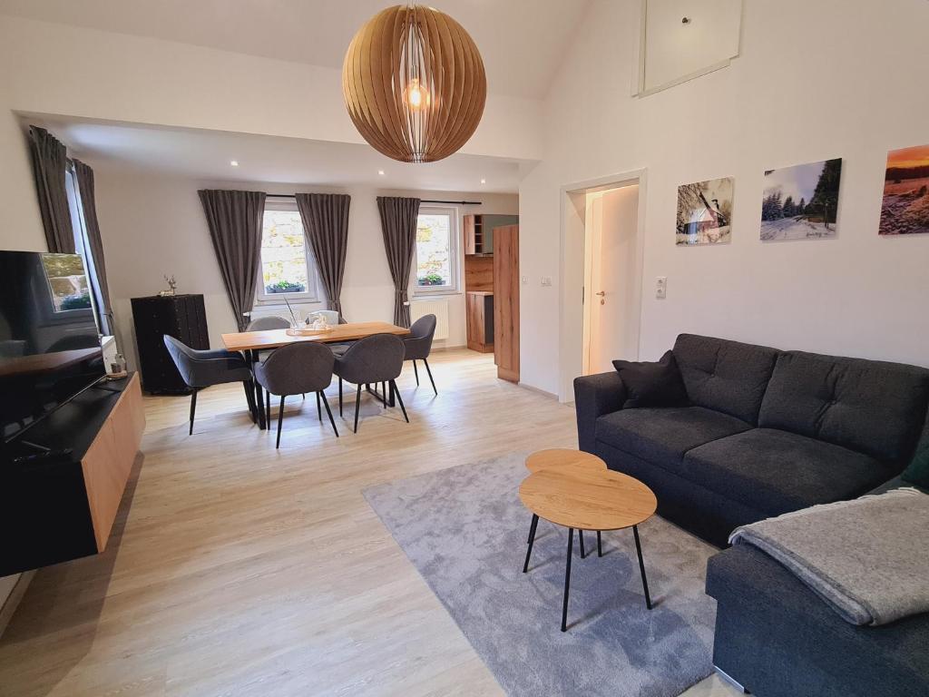 uma sala de estar com um sofá e uma mesa em FeWo Suhl-Heinrichs, 2 Schlafzimmer, 2 Terrassen em Suhl