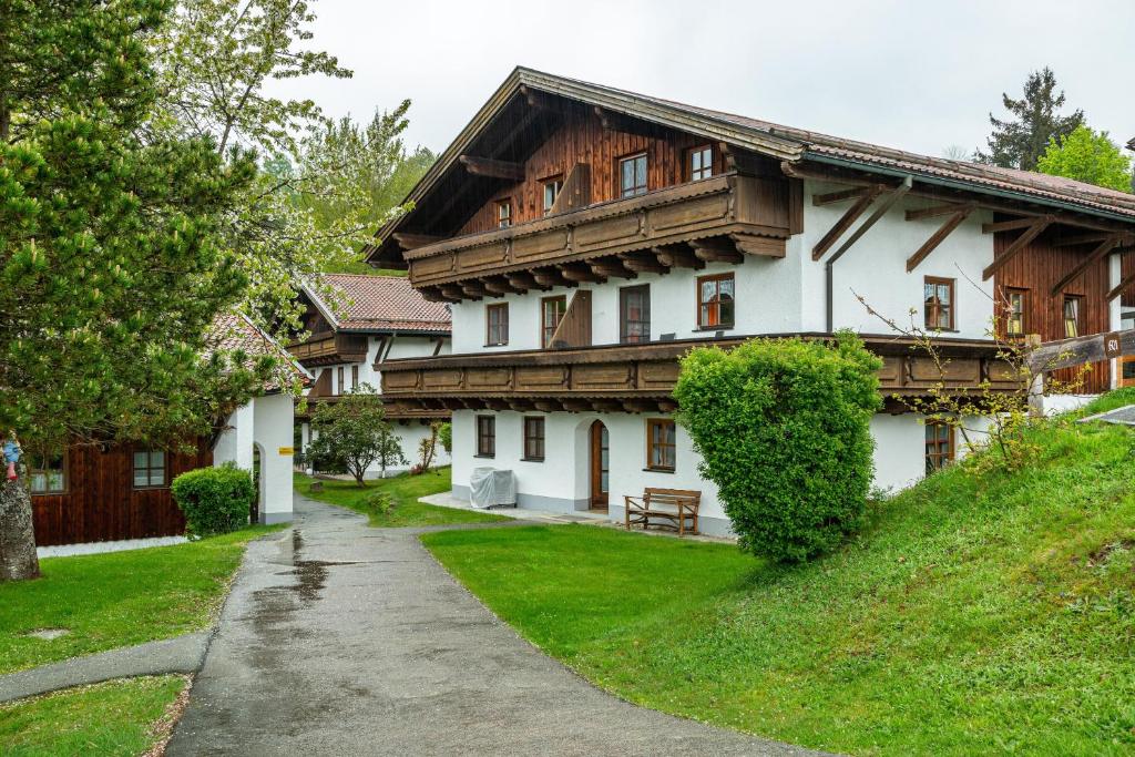 ein großes weißes Haus mit Holzdach in der Unterkunft Komfortwohnung mit Pool und Sauna in Hauzenberg