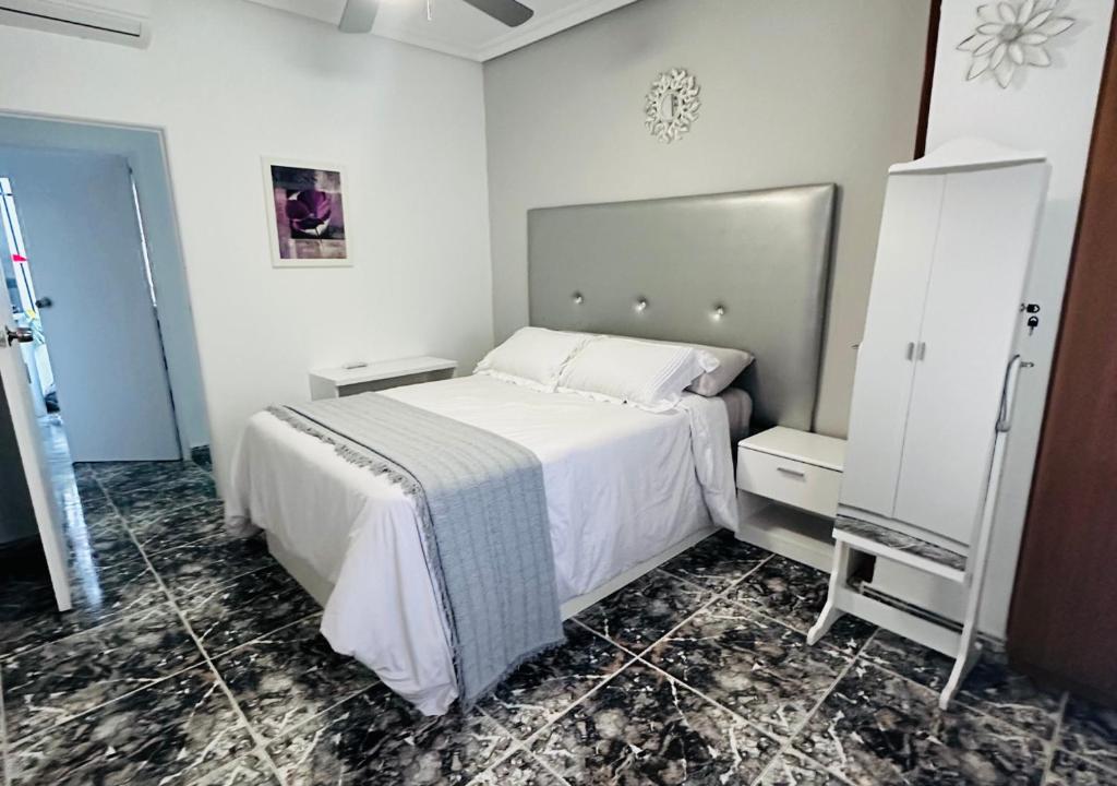 1 dormitorio con 1 cama blanca grande en una habitación en Coqueto Apartamento, en Martos