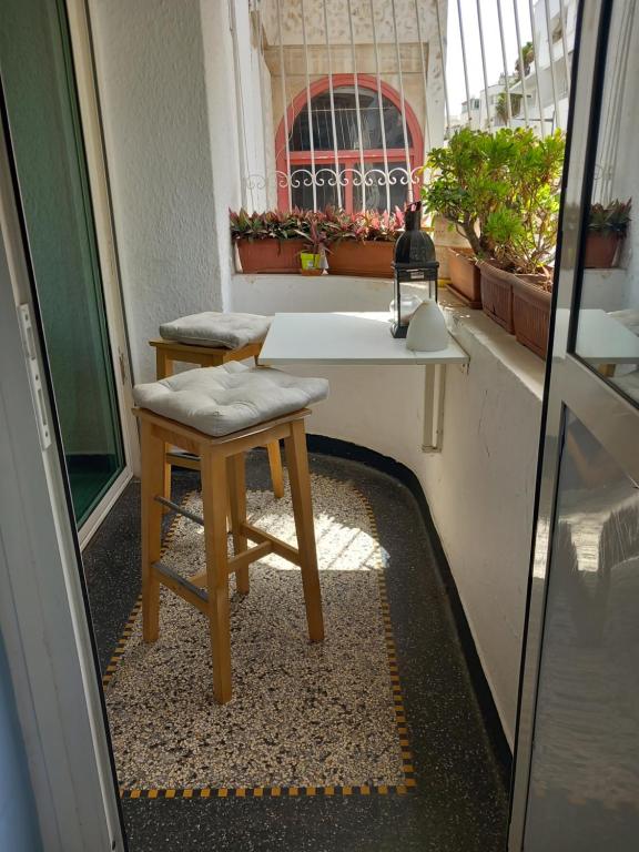 une table et un tabouret assis sur un balcon dans l'établissement appartement cosy et chaleureux, à Rabat