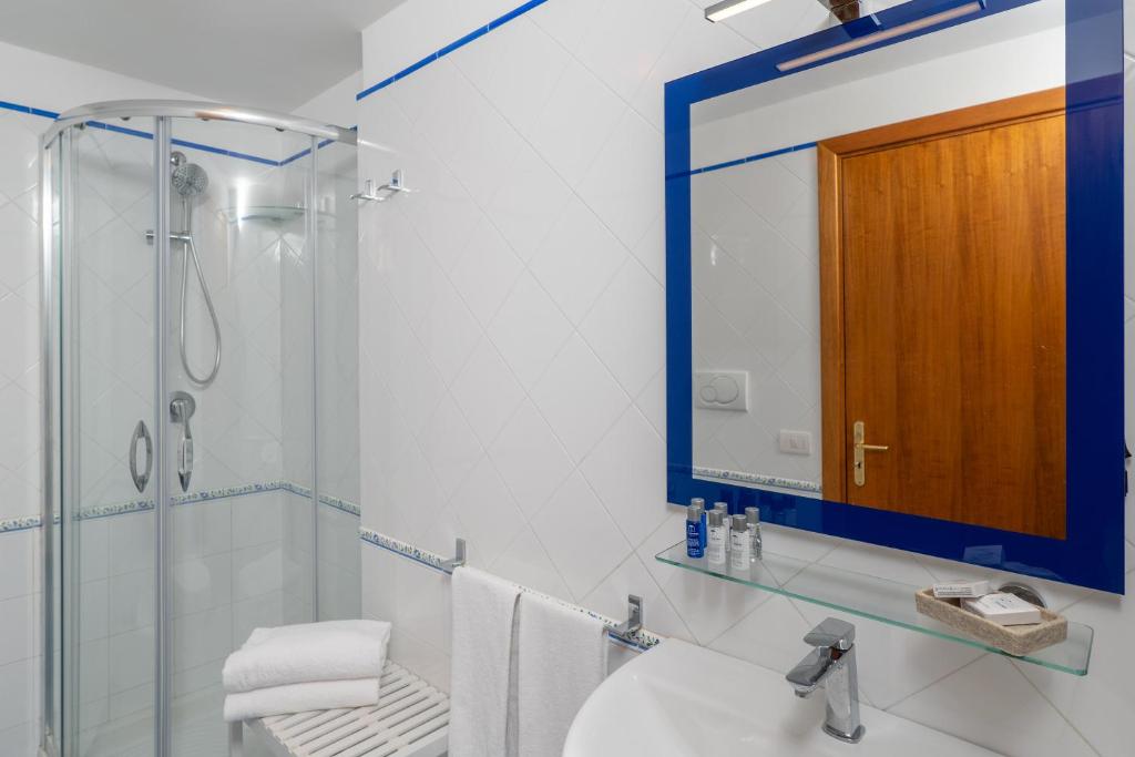Un baño con lavabo, ducha y espejo. en Villa Marea, en Praiano
