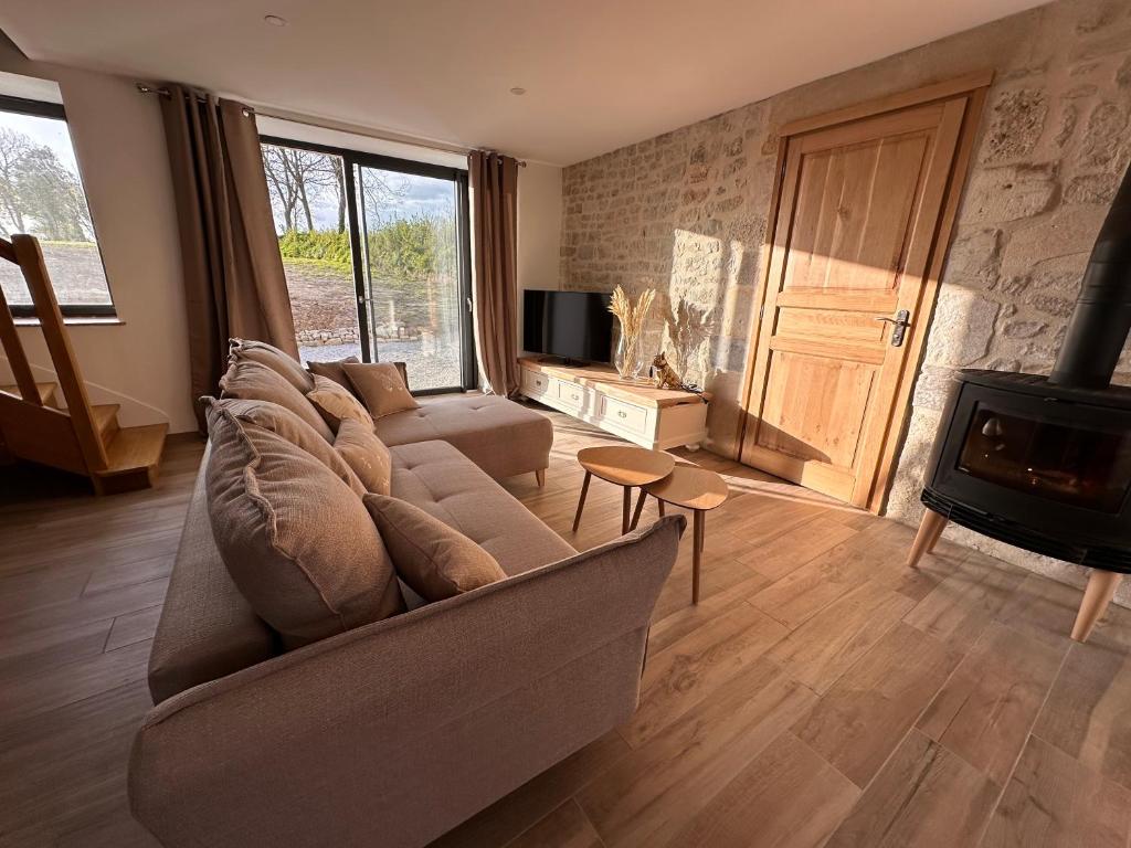 un salon avec un canapé et une cheminée dans l'établissement Gîte Cotentin Sweet Home, à Blosville
