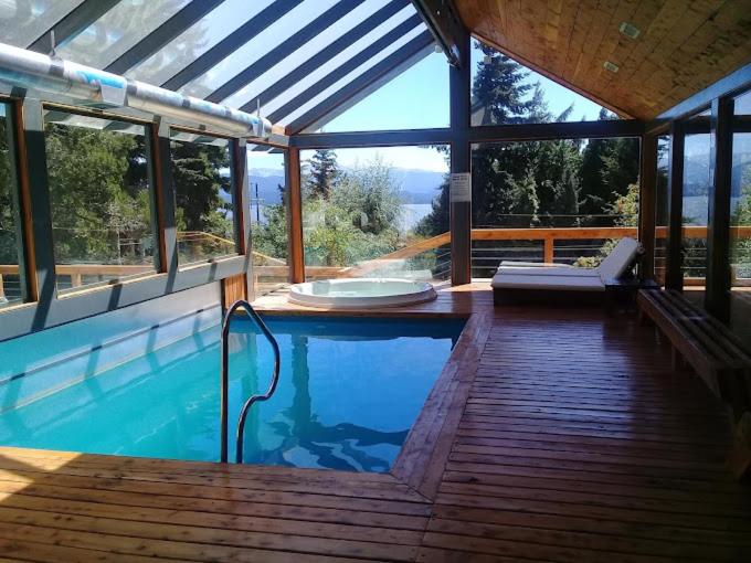 a swimming pool in a house with a wooden deck at Alojamiento en Aldea Andina in San Carlos de Bariloche