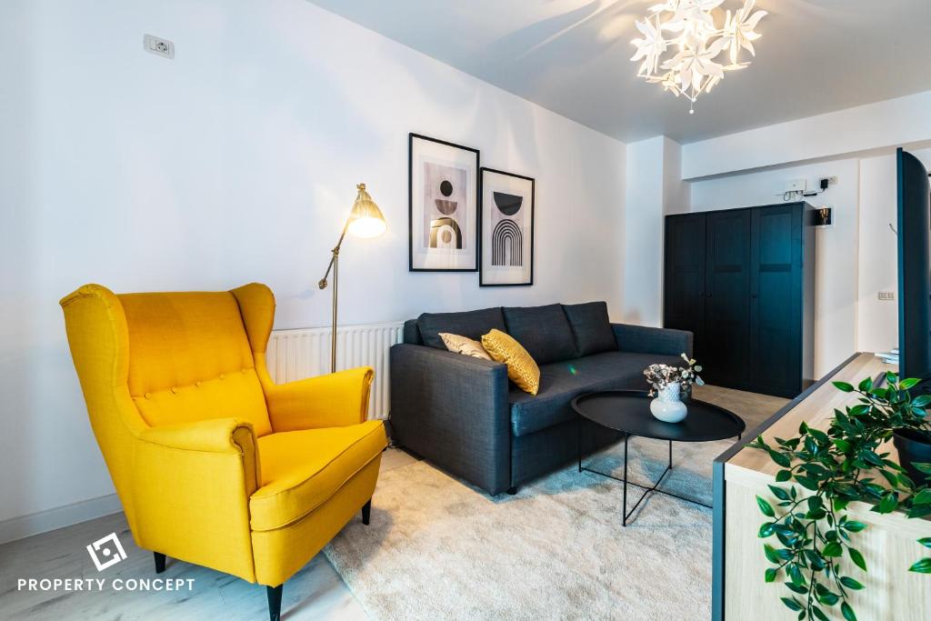 ein Wohnzimmer mit einer Couch und einem Sessel in der Unterkunft Central Residence Apartment 928 in Vatra Mînăstirii Cotroceni