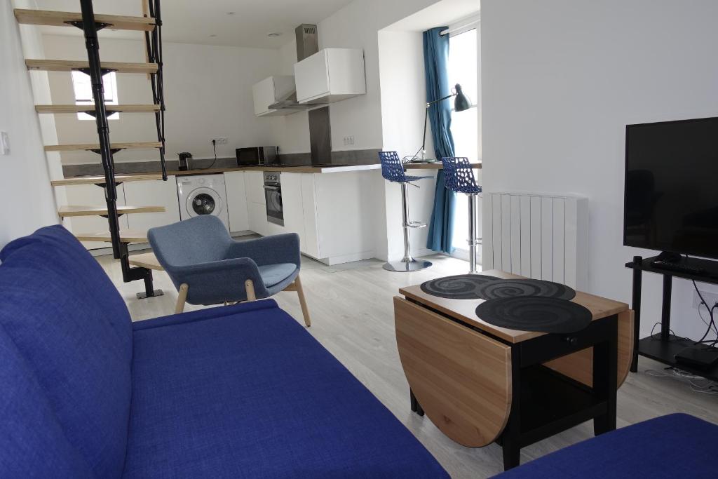 un salon avec un canapé bleu et une télévision dans l'établissement Dijon : Superbe appartement hyper centre en duplex, à Dijon