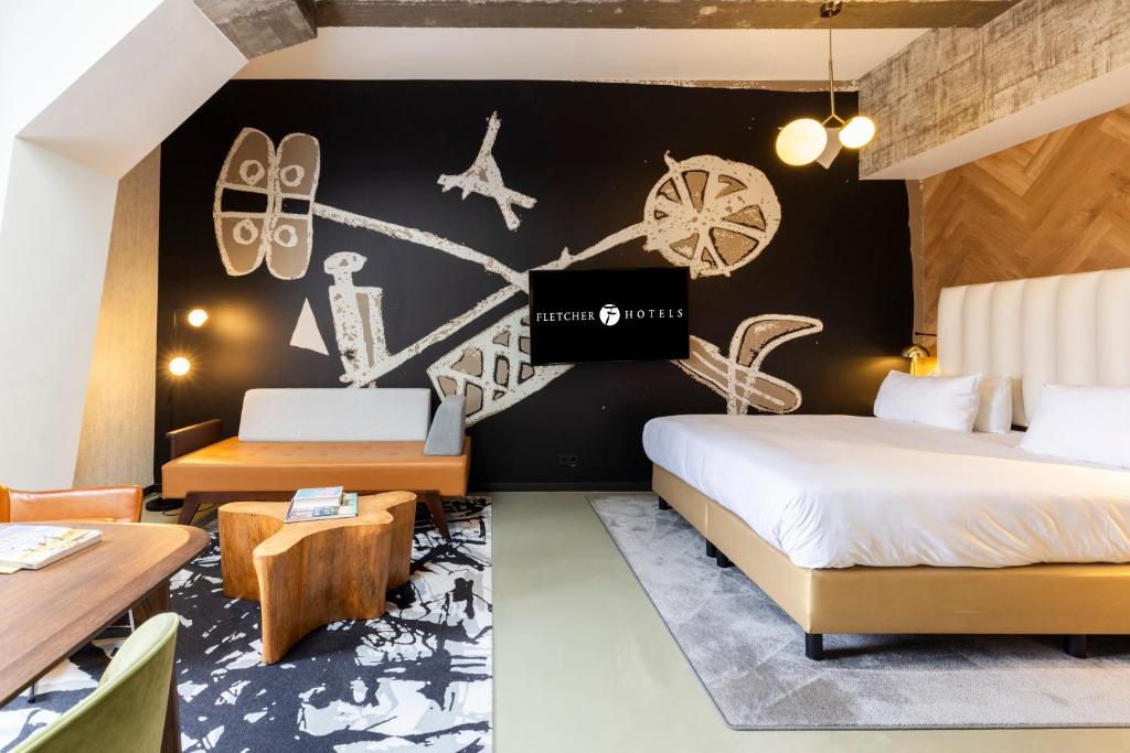 a hotel room with two beds and a wall with drawings at Fletcher Boutique Hotel Slaak-Rotterdam in Rotterdam