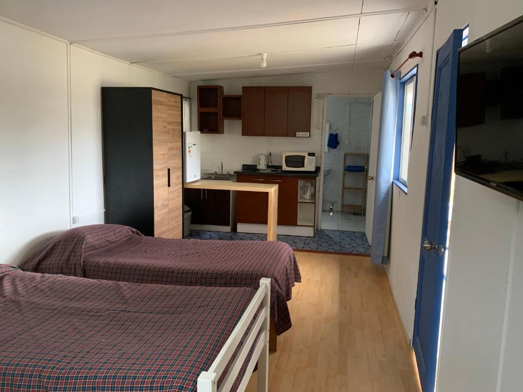 une petite chambre avec deux lits et une cuisine dans l'établissement SOL DE LA PALMA, à Quillota