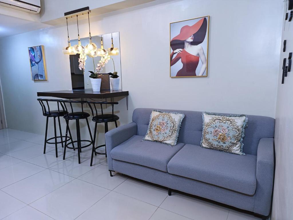 a living room with a blue couch and a table at 1BR and Studio Condo Unit @ 150 Newport near NAIA 3 in Manila