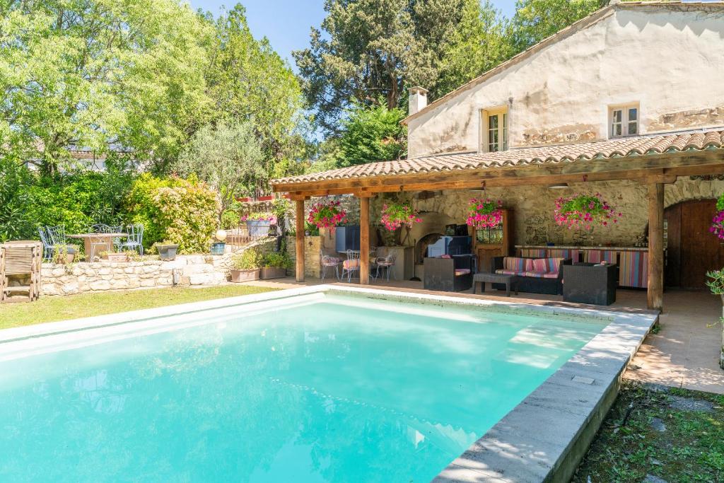 uma piscina exterior em frente a uma casa em La Tour em Saint-Rémy-de-Provence