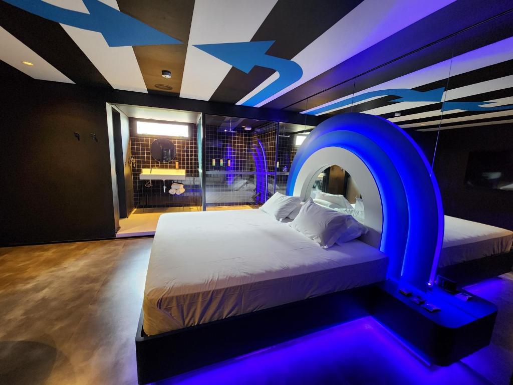 um quarto com uma cama com iluminação azul em Andar de Cima Suítes em São Paulo
