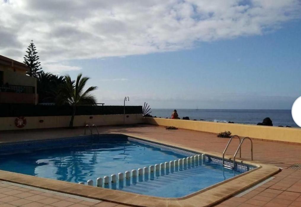 una piscina con el océano en el fondo en Apartamentos Trasmallo 1, en Playa Calera