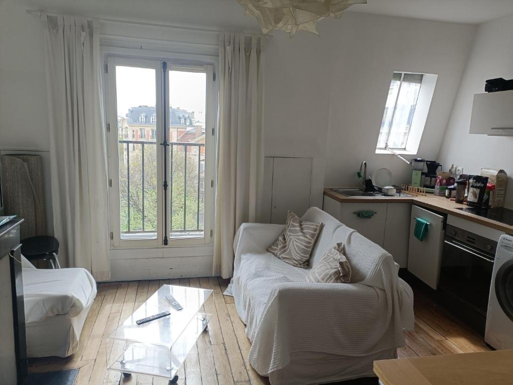un salon avec un canapé blanc et une cuisine dans l'établissement Sunny apartment in Paris Batignolles, à Paris