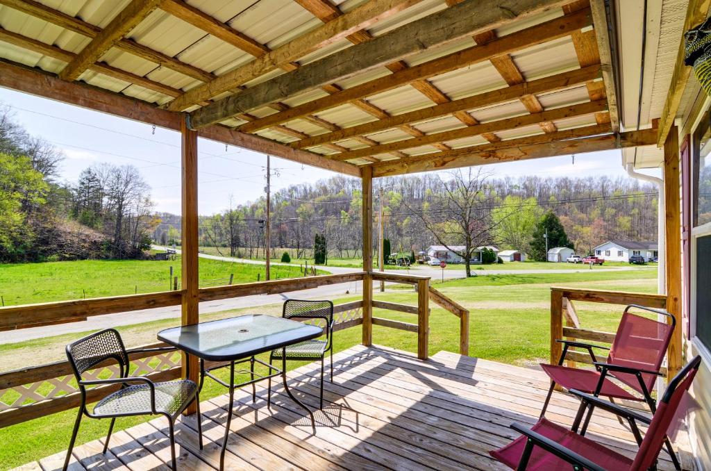 een afgeschermde veranda met een tafel en stoelen en uitzicht op een veld bij Rural Kentucky Vacation Rental about 15 Mi to London! 