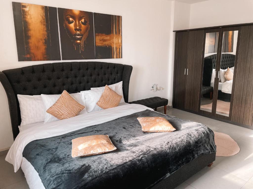 una camera da letto con un grande letto con due cuscini sopra di Airport West 3BR apartment a Accra