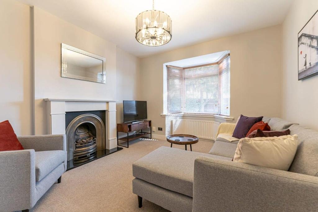 a living room with a couch and a fireplace at Spacious 3 Bedroom house, 10 mins to Birmingham in Birmingham