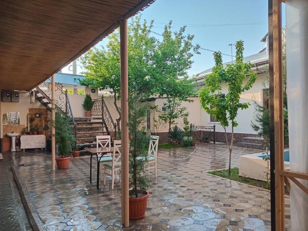 a patio with trees and a table and chairs at SAMARKAND AMIRA in Samarkand