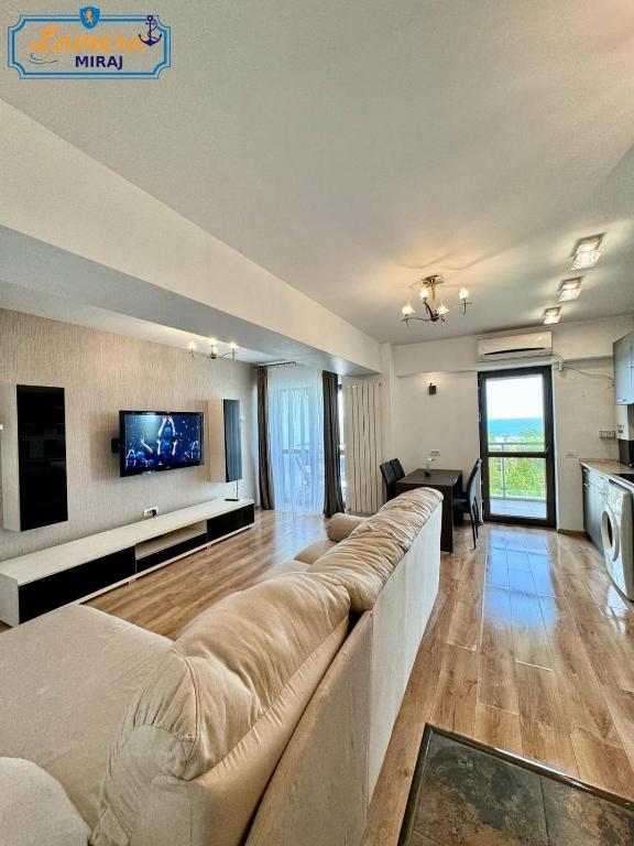 een woonkamer met een grote bank en een tv bij Lamera-Miraj sea view in Mamaia