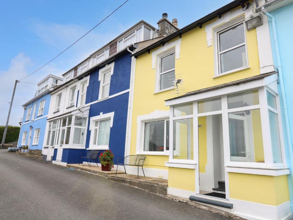 a row of brightly painted houses on a street at Ty-Clyd in New Quay