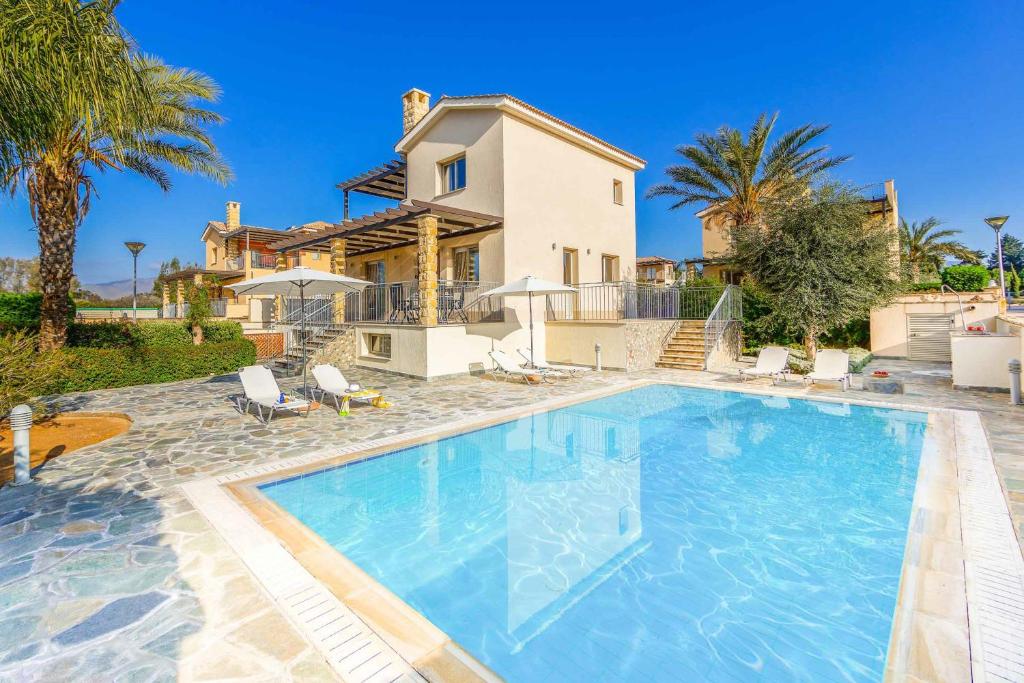 a large swimming pool in front of a house at Villa Paralia in Polis Chrysochous